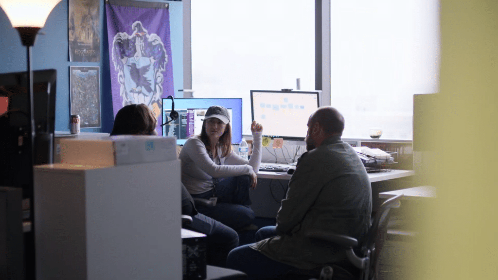 Colleagues in discussion in front of computer monitors